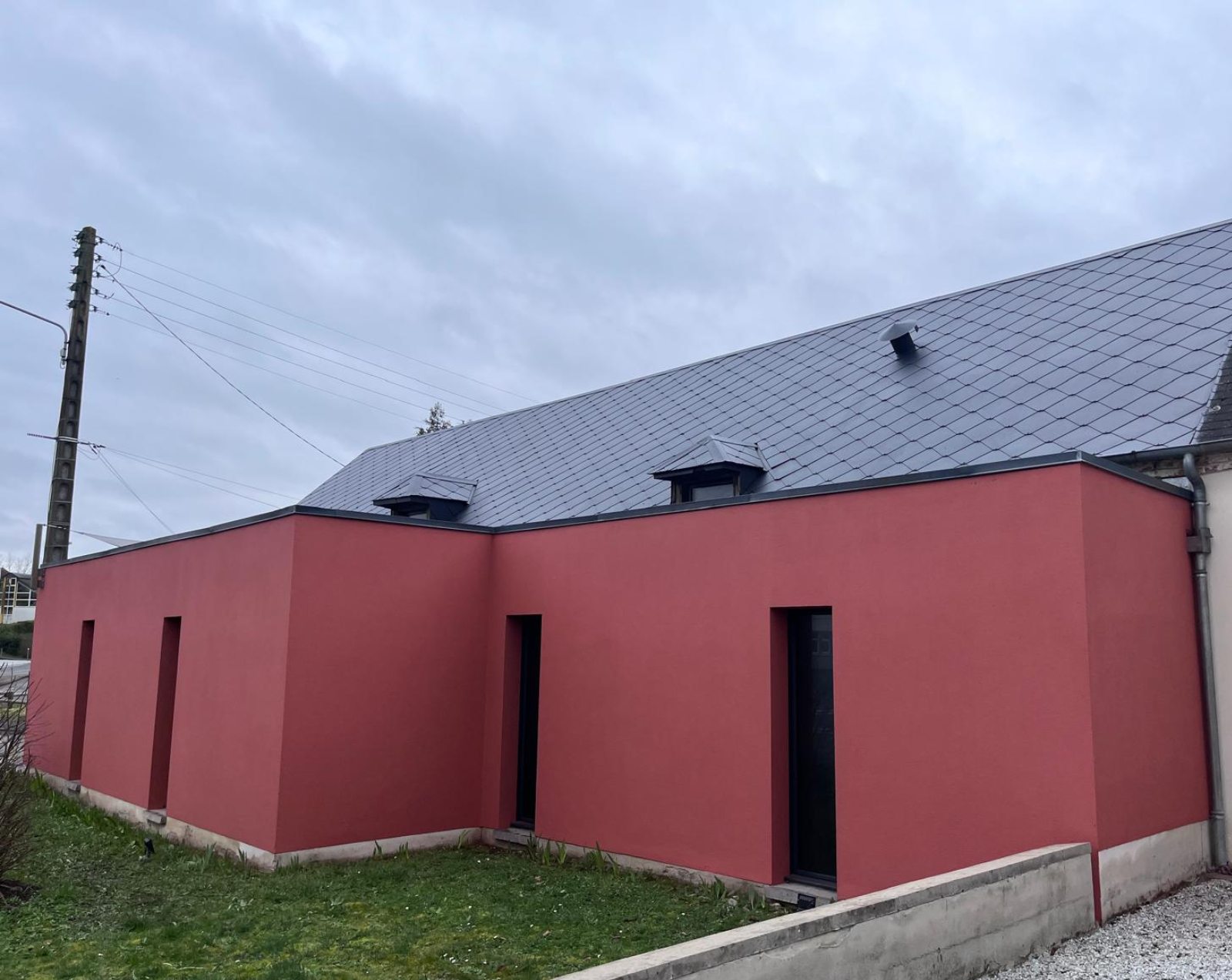 Façade rouge et toiture en ardoises rénovées